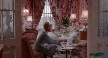 Movie still from “Overboard” (1987), directed by Garry Marshall – A woman sitting on a chair in front of a window; Wide shot, High angle