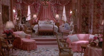 Movie still from “Overboard” (1987), directed by Garry Marshall – A room with a bed , chair , table and a lot of furniture; Extreme Wide shot, High angle