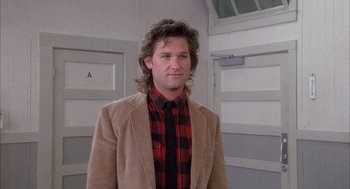 Movie still from “Overboard” (1987), directed by Garry Marshall – A man in a plaid shirt and a brown jacket; Medium shot, Low angle