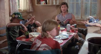 Movie still from “Overboard” (1987), directed by Garry Marshall – A group of people sitting at a table with plates of food; Medium shot, Over the shoulder angle