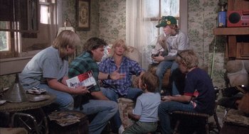 Movie still from “Overboard” (1987), directed by Garry Marshall – A group of people sitting in a living room; Medium shot, High angle