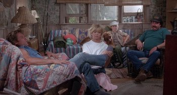 Movie still from “Overboard” (1987), directed by Garry Marshall – A woman sitting on a couch in a living room; Wide shot, High angle