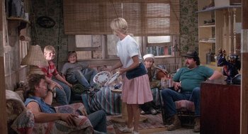 Movie still from “Overboard” (1987), directed by Garry Marshall – A group of people sitting in a living room; Wide shot, High angle