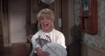 Movie still from “Overboard” (1987), directed by Garry Marshall – A woman is holding a white plate in her hand; Medium shot, High angle
