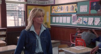Movie still from “Overboard” (1987), directed by Garry Marshall – A woman standing in front of a wall with many pictures on it; Medium shot, Over the shoulder angle