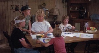 Movie still from “Overboard” (1987), directed by Garry Marshall – A group of people sitting at a table doing arts and crafts; Medium shot, Over the shoulder angle
