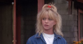 Movie still from “Overboard” (1987), directed by Garry Marshall – A woman with blonde hair wearing a white shirt and a denim jacket; Close Up shot, Over the shoulder angle