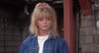 Movie still from “Overboard” (1987), directed by Garry Marshall – A woman in a jean jacket with a red bow in her hair; Close Up shot, Low angle