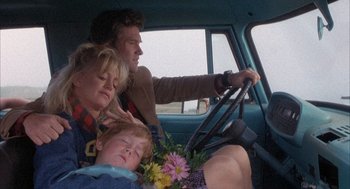 Movie still from “Overboard” (1987), directed by Garry Marshall – A man and a woman and a child in the back of a car; Medium shot, High angle