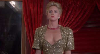 Movie still from “Overboard” (1987), directed by Garry Marshall – A woman wearing a gold dress and a red necklace; Medium shot, Over the shoulder angle