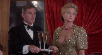 Movie still from “Overboard” (1987), directed by Garry Marshall – A man and a woman holding champagne flutes in front of a mirror; Medium shot, Over the shoulder angle