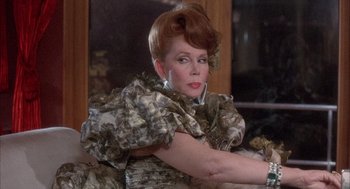 Movie still from “Overboard” (1987), directed by Garry Marshall – An older woman with red hair wearing a dress; Close Up shot, Over the shoulder angle