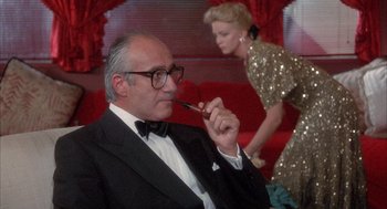 Movie still from “Overboard” (1987), directed by Garry Marshall – An older man in a tuxedo smoking a pipe; Medium shot, Low angle
