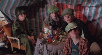 Movie still from “Overboard” (1987), directed by Garry Marshall – A group of people sitting around a table with food on top of it; Medium shot, High angle