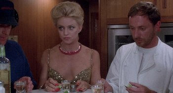 Movie still from “Overboard” (1987), directed by Garry Marshall – A woman sitting at a dinner table with a man; Close Up shot, Low angle