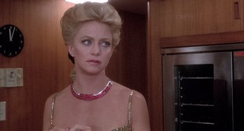 Movie still from “Overboard” (1987), directed by Garry Marshall – A woman in a gold dress with a red necklace; Close Up shot, Over the shoulder angle