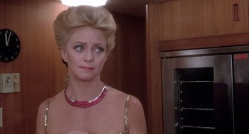 Movie still from “Overboard” (1987), directed by Garry Marshall – A woman in a gold dress and a red necklace; Close Up shot, Over the shoulder angle