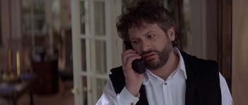 Movie still from “Mrs. Doubtfire” (1993), directed by Chris Columbus – A man talking on a cell phone while wearing a suit; Close Up shot, Low angle