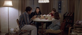 Movie still from “Mrs. Doubtfire” (1993), directed by Chris Columbus – Four people sitting at a table eating food; Medium shot, High angle