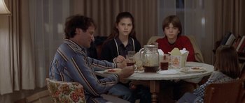 Movie still from “Mrs. Doubtfire” (1993), directed by Chris Columbus – A man sitting at a dinner table with three children; Medium shot, Over the shoulder angle