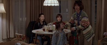 Movie still from “Mrs. Doubtfire” (1993), directed by Chris Columbus – A group of people sitting at a table with food; Medium shot, Over the shoulder angle