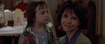 Movie still from “Mrs. Doubtfire” (1993), directed by Chris Columbus – A woman and a girl are smiling for the camera; Close Up shot, Over the shoulder angle