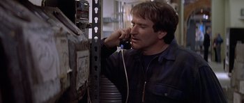 Movie still from “Mrs. Doubtfire” (1993), directed by Chris Columbus – A man talking on a phone next to an electrical box; Close Up shot, Low angle