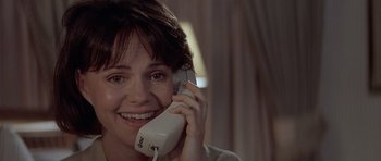 Movie still from “Mrs. Doubtfire” (1993), directed by Chris Columbus – A woman smiles while talking on a phone; Close Up shot, High angle