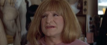 Movie still from “Mrs. Doubtfire” (1993), directed by Chris Columbus – An older woman with long blonde hair wearing a pink shirt; Close Up shot, Over the shoulder angle