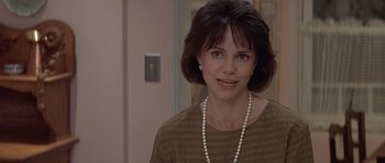 Movie still from “Mrs. Doubtfire” (1993), directed by Chris Columbus – A person wearing a dress and a pearl necklace; Close Up shot, Over the shoulder angle