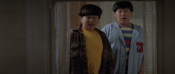 Movie still from “Mrs. Doubtfire” (1993), directed by Chris Columbus – Two young men standing next to each other in front of a mirror; Medium shot, Low angle