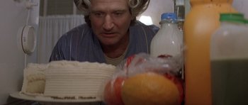 Movie still from “Mrs. Doubtfire” (1993), directed by Chris Columbus – A man sitting in front of a table with food on top of it; Close Up shot, Overhead angle