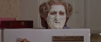 Movie still from “Mrs. Doubtfire” (1993), directed by Chris Columbus – A woman with a face mask on sitting at a counter; Close Up shot, Over the shoulder angle