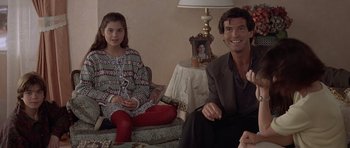 Movie still from “Mrs. Doubtfire” (1993), directed by Chris Columbus – A man and a little girl sitting on a couch; Medium shot, Over the shoulder angle