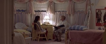 Movie still from “Mrs. Doubtfire” (1993), directed by Chris Columbus – Two women are sitting in a room with a lamp; Wide shot, High angle