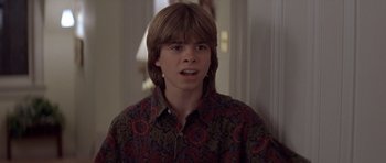 Movie still from “Mrs. Doubtfire” (1993), directed by Chris Columbus – A young man with long hair and a floral shirt; Close Up shot, Over the shoulder angle