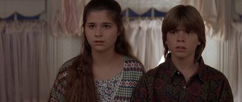 Movie still from “Mrs. Doubtfire” (1993), directed by Chris Columbus – Two young girls standing next to each other in a room; Medium shot, Over the shoulder angle