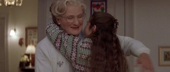 Movie still from “Mrs. Doubtfire” (1993), directed by Chris Columbus – An older woman and a young girl are hugging; Close Up shot, Over the shoulder angle