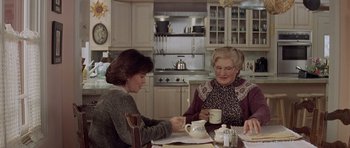 Movie still from “Mrs. Doubtfire” (1993), directed by Chris Columbus – Two women sitting at a table with cups of tea; Medium shot, Over the shoulder angle
