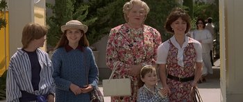 Movie still from “Mrs. Doubtfire” (1993), directed by Chris Columbus – A group of people standing next to each other on a street; Medium shot, Over the shoulder angle