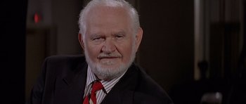 Movie still from “Mrs. Doubtfire” (1993), directed by Chris Columbus – An older man wearing a suit and a red neck tie; Close Up shot, High angle