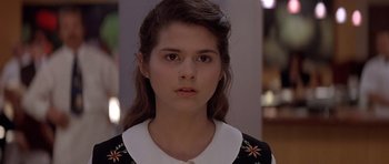 Movie still from “Mrs. Doubtfire” (1993), directed by Chris Columbus – A young woman with long hair wearing a black and white dress; Close Up shot, Over the shoulder angle