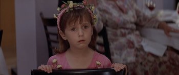 Movie still from “Mrs. Doubtfire” (1993), directed by Chris Columbus – A little girl wearing a pink dress and a flower crown; Close Up shot, Over the shoulder angle