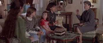 Movie still from “Mrs. Doubtfire” (1993), directed by Chris Columbus – A woman and two young children sitting on a chair; Medium shot, Over the shoulder angle