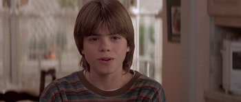 Movie still from “Mrs. Doubtfire” (1993), directed by Chris Columbus – A young man with long hair and a striped shirt; Close Up shot, Low angle