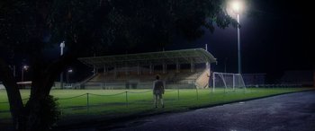 A man standing in front of an empty bleachers