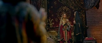 Movie still from “Padmaavat” (2018), directed by Sanjay Leela Bhansali – A woman dressed in traditional indian garb in front of an ornate wall; Wide shot, Over the shoulder angle