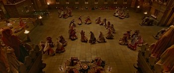 Movie still from “Padmaavat” (2018), directed by Sanjay Leela Bhansali – A group of women in traditional dress dancing in an indoor arena; Extreme Wide shot, Overhead angle