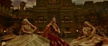 Movie still from “Padmaavat” (2018), directed by Sanjay Leela Bhansali – A group of women dressed in traditional garb dance; Wide shot, Low angle