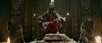 Movie still from “Padmaavat” (2018), directed by Sanjay Leela Bhansali – A man sitting on top of a throne in a room; Wide shot, Low angle